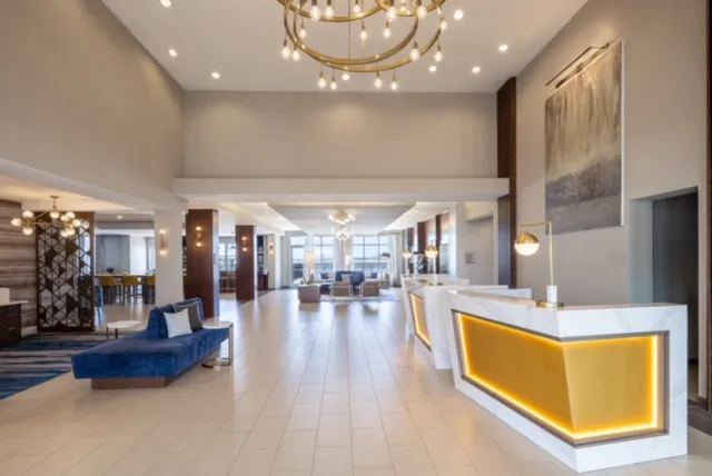 Lobby with illuminated gold reception desk and blue lounge seating