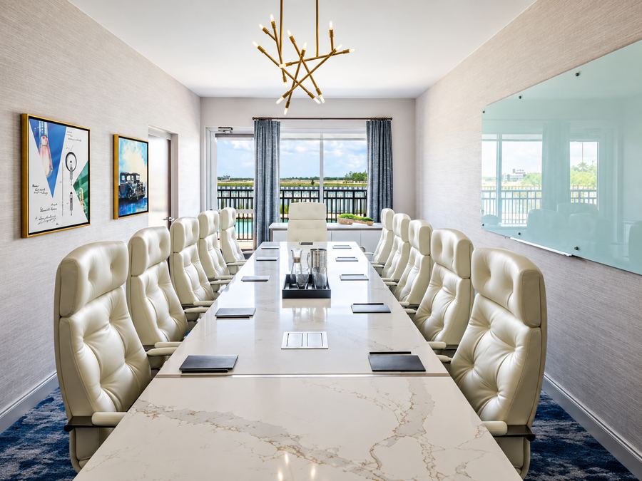 Boardroom with marble conference table and white leather executive chairs