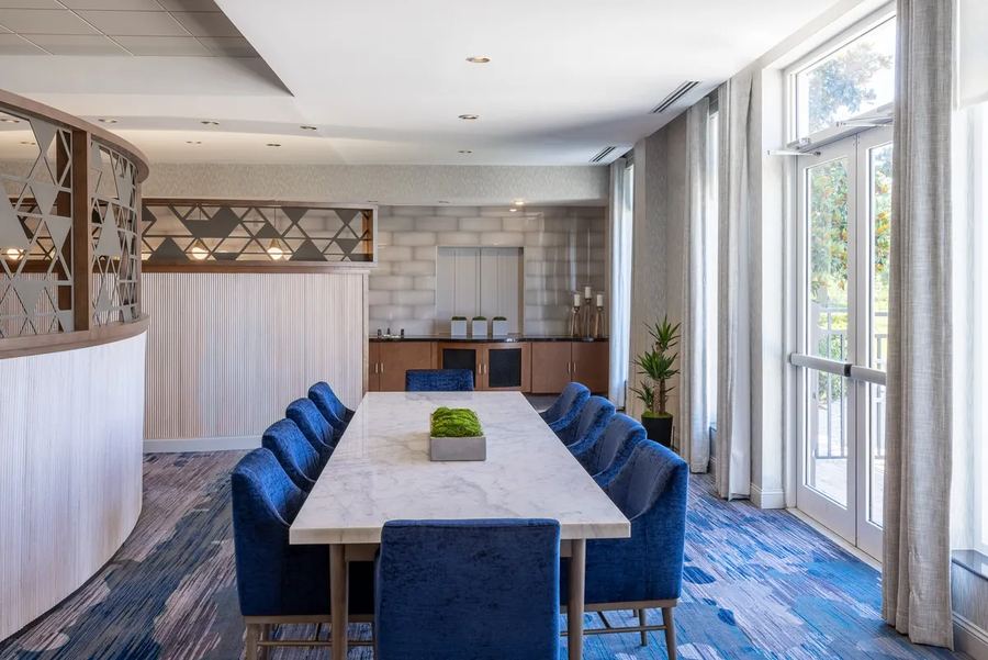 Private dining room with blue velvet chairs and a long stone table