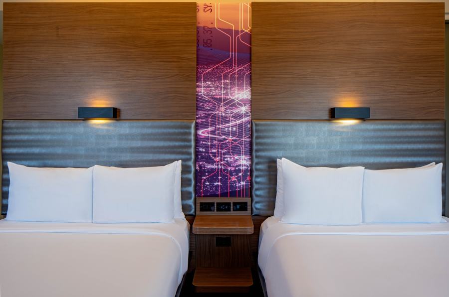 Double queen beds with illuminated headboard art