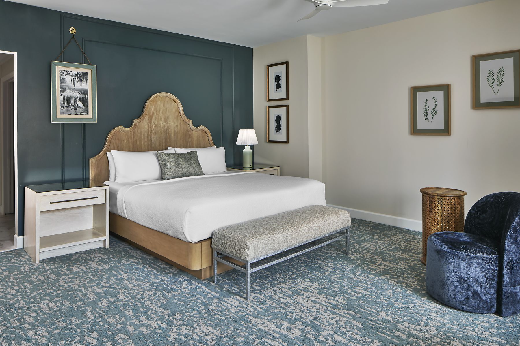 King studio with carved headboard and blue accent wall