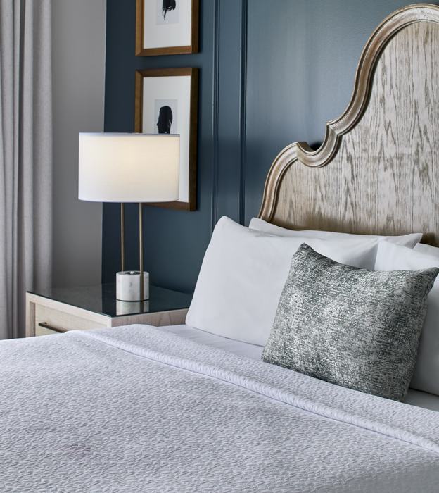 King bed vignette with carved headboard