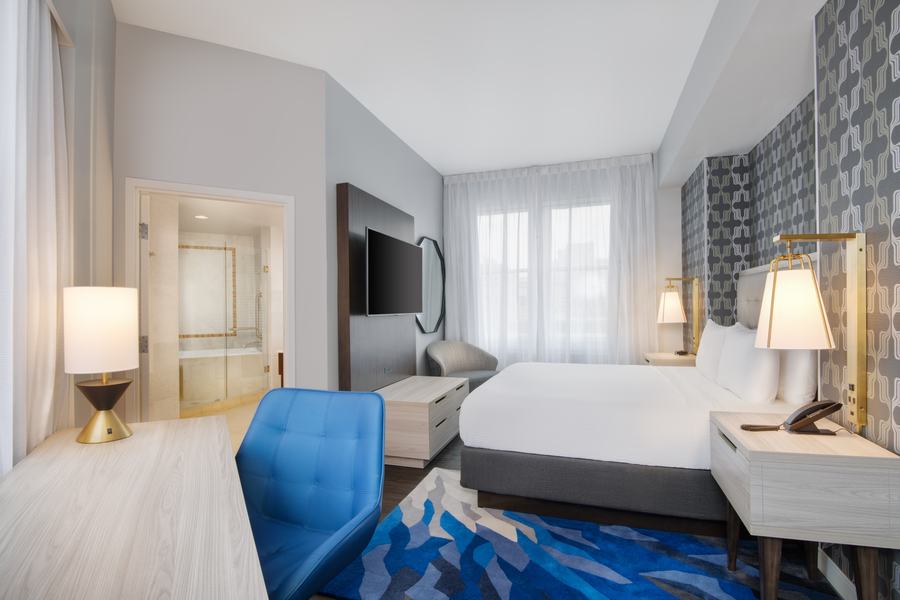 Corner king guest room with geometric wallcovering