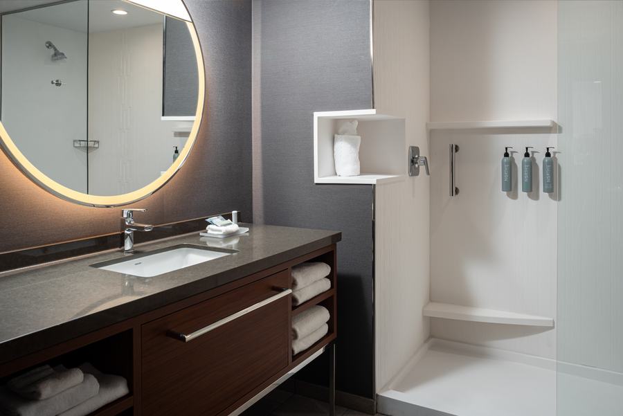 Guest bathroom with illuminated round mirror