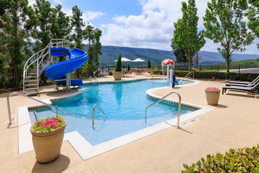 Outdoor pool with water slide and mountain views