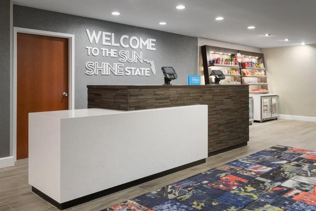 Front desk with 'Welcome to the Sunshine State' wall