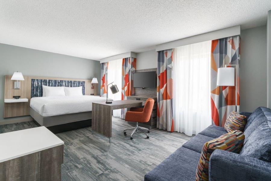 King guest room with sofa and colourful drapery