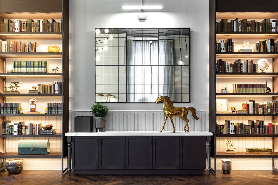 Console vignette between lit bookshelves